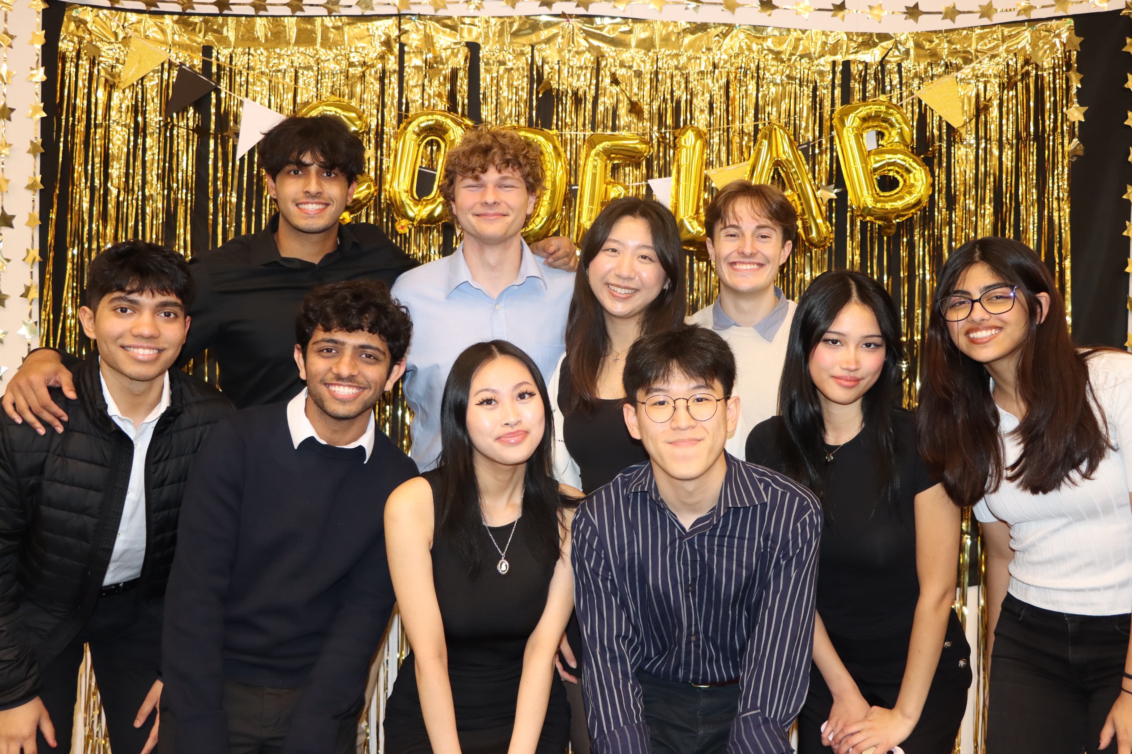 The Codelab team gathered in front of a gold celebration backdrop